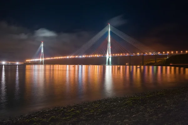 Nacht uitzicht op de brug op het Russische eiland. Vladivostok. — Stockfoto