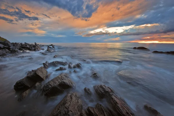 Pobřeží moře po bouři při západu slunce. — Stock fotografie