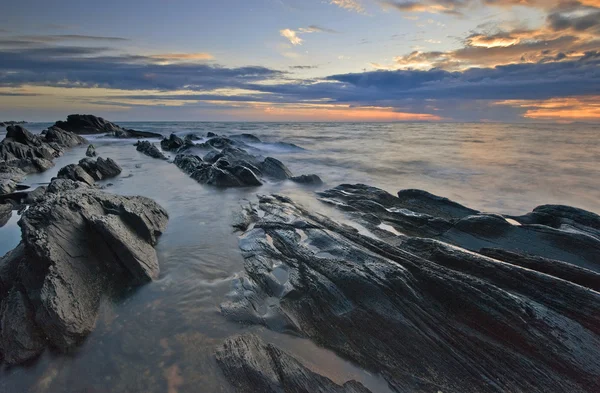 Costa del mar después de la tormenta al atardecer . — Foto de Stock