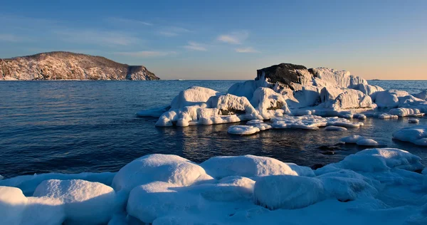 Stenarna täckt med is på stranden. — Stockfoto