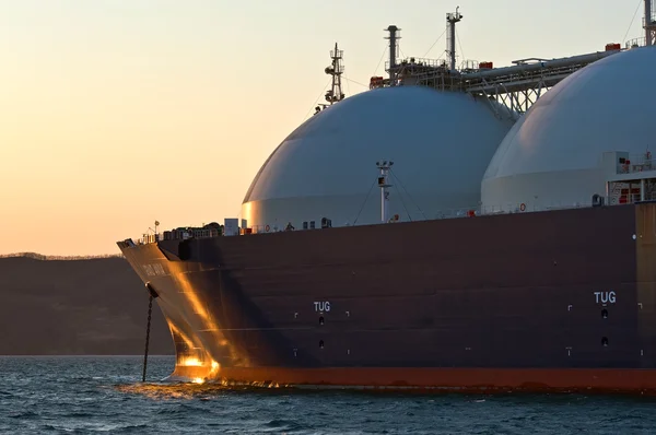 LNG taşıyıcı Grand Aniva Nakhodka bağlantı noktası yollarda gün batımında. Rusya'nın Uzakdoğu. Doğu (Japonya) deniz. 31.03.2014
