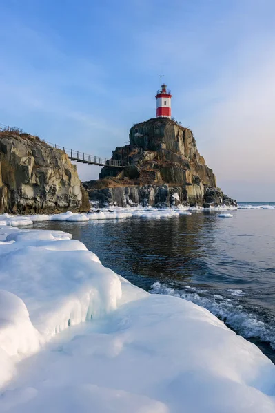 Winterbild Leuchtturm auf einem einsamen Felsen. — Stockfoto