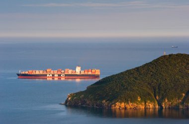 Büyük konteyner gemisi şirket Msc günbatımında koyda demirlemiş olan. Nakhodka Bay. Doğu (Japonya) deniz. 15.08.2014