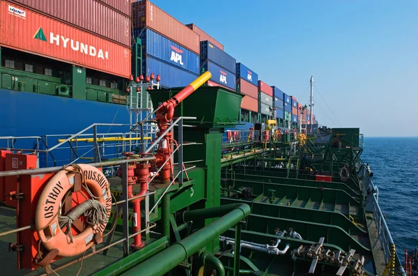 Tanker Ostrov Russkiy raid bunker op de containerschip Hyundai-bedrijven... Nachodka Bay. East (Japan) Zee. 19.04.2014 — Stockfoto