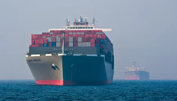 Container navio Hamber Bridge e petroleiro Nordbay ancorado nas estradas. Baía de Nakhodka. Mar do Leste (Japão). 19.04.2014 — Fotografia de Stock