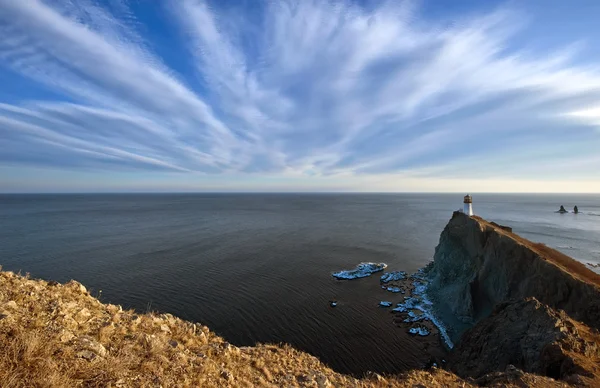 Lighthouse on a high cliff on the coast. — Stock Photo, Image