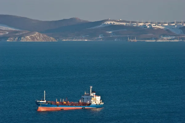 Citerne de l'île russe à l'ancre dans les routes sur fond de terminal pétrolier. Baie de Nakhodka. Mer Est (Japon). 05.03.2015 — Photo