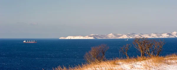 Loď, pohybující se po moři podél pobřeží hornaté zimy. Nakhodka Bay. Východ (Japonsko) moře. 02.01.2013 — Stock fotografie