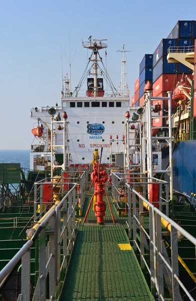 Tanker Ostrov Russkiy raid bunker op de containerschip Hyundai-bedrijven. Nachodka Bay. East (Japan) Zee. 19.04.2014 — Stockfoto