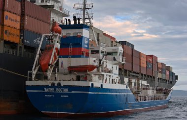 Nakhodka, Rusya Federasyonu-02.07.2015: Bunkering tanker Zaliv'e Vostok konteyner gemisi Nyk Rigel. Nakhodka Bay. Doğu (Japonya) deniz. 02.07.2015