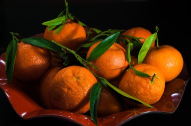 Mandalina kırmızı bir kase üzerinde