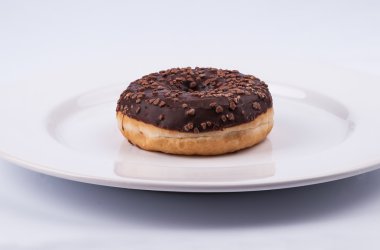 Beyaz plaka üzerinde çikolata sırlı çörek