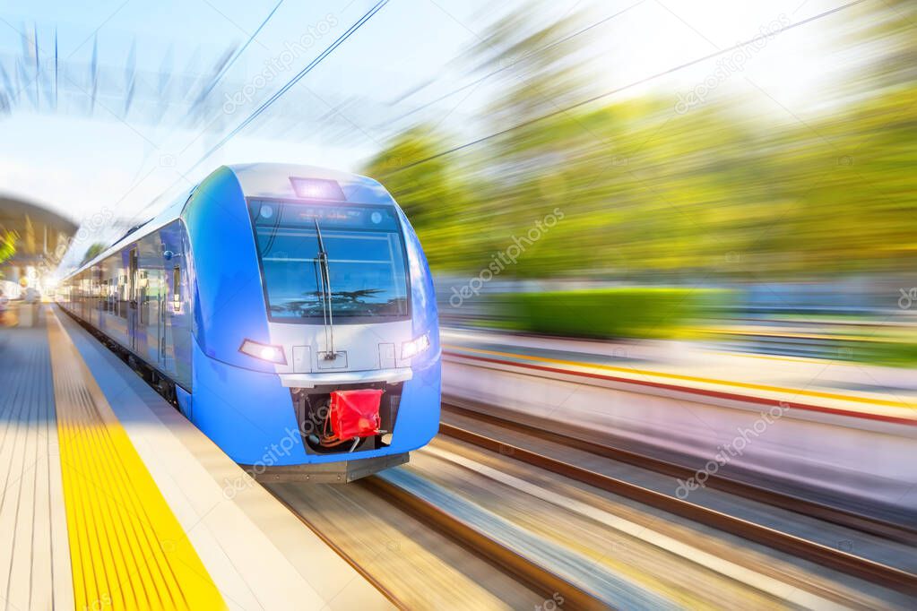 Train motion high speed rushes through the city station on a sunny day