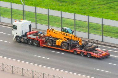 Karavan platformlu, asansör vagonu platformlu, hidrolik ve mekanik ekipmanlı bir kamyon.