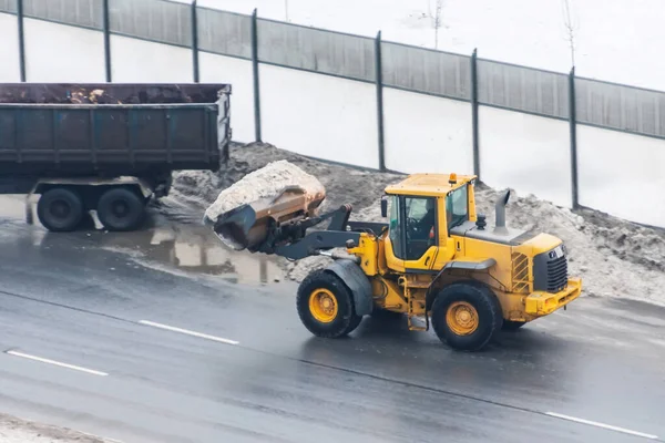 Tractor Met Een Emmer Sneeuwladingen Achterkant Van Een Vrachtwagen — Stockfoto