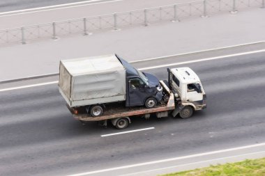 Kazadan sonra hurdaya dönmüş kamyonetli bir kamyon, asfalt yolda kaputu göçmüş.