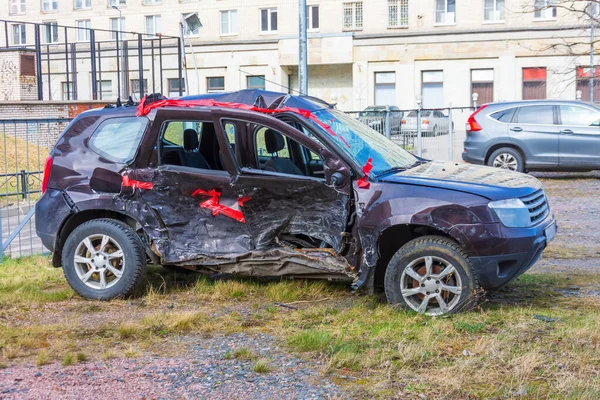 Wrecked crumpled car from the right side after a severe accident with a distorted body and broken windows, after a powerful blow side view