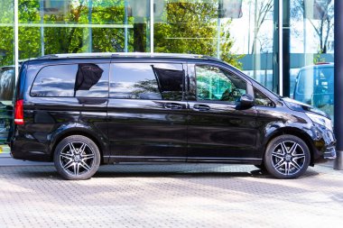 Siyah Mercedes-Benz V sınıfı, otoparkta bir minivan. Rusya, Saint-Petersburg. 14 Mayıs 2020