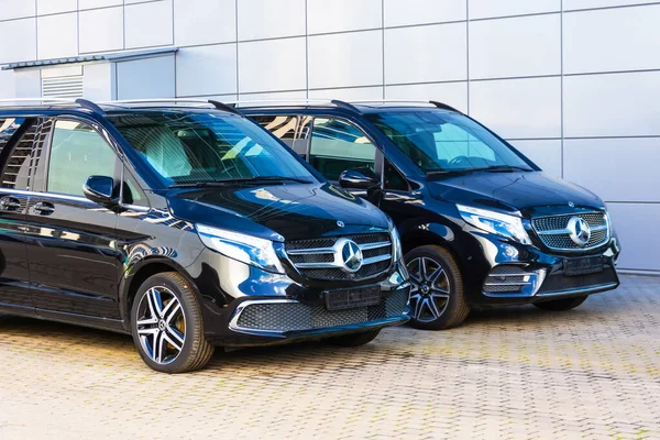 Siyah Mercedes-Benz V sınıfı, otoparkta öndeki minivan. Rusya, Saint-Petersburg. 26 Ağustos 2020