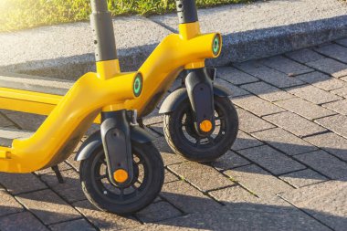 Otoparkta arka arkaya elektrikli scooterlar. Şehir bisiklet kiralama sistemi, sokakta halka açık scooter 'lar.