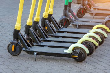 Otoparkta arka arkaya elektrikli scooterlar. Şehir bisiklet kiralama sistemi, sokakta halka açık scooter 'lar.