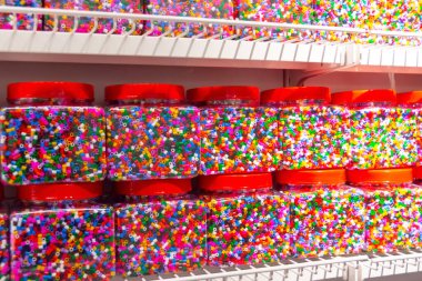 Kavanozlarda çok renkli küçük bir mozaik bir insanın fantezisinde çeşitli şekiller yaratmak için. Cımbız ve mozaik plaka