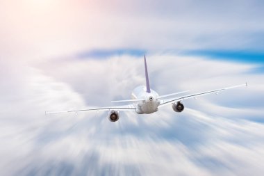 Uçak kümülüs bulutlarının üzerinden hızla ve dikiz aynasıyla uçar.