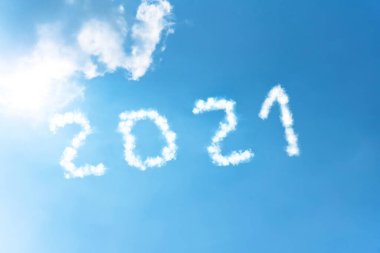 Parlak bir güneş tarafından aydınlatılan beyaz bulutların dumanından mavi gökyüzünün arka planında 2021 numaralı sembol.