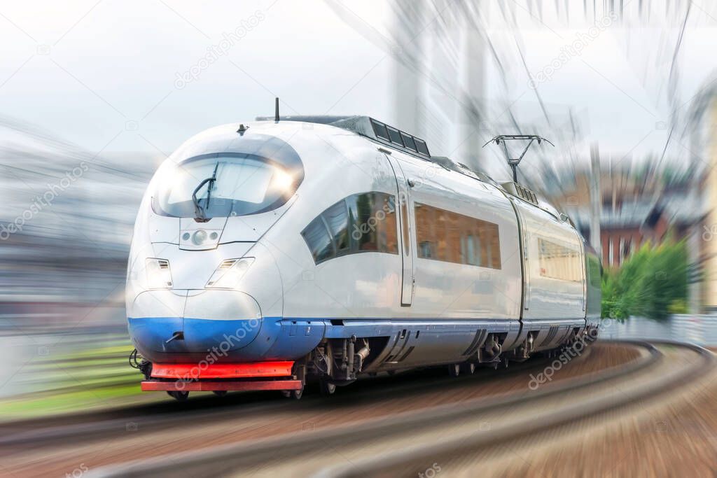 High-speed train with headlights on is driving through a corner at fast speed