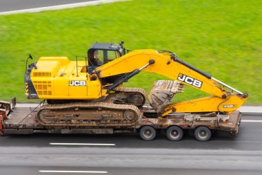 Kazıcı JCB kamyonu kargo platformu şehir otoyoluna yüklendi. Rusya, Saint-Petersburg. 18 Mayıs 2020