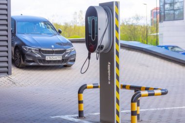 BMW arabası elektrik santralinin elektrik şebekesine park edilmiş. Rusya, Saint-Petersburg. 13 Mayıs 2020