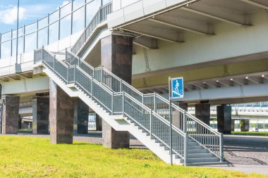 Köprüden karşıya geçen yayalar. Yayaların güvenliği için köprünün yakınındaki geçişin işareti.