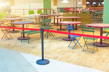 Kapalı yemek bölümleri boş masa ve sandalyeler servis ve hızlı ahşap alanlarda kırmızı uçuş güvertesi, koronavirüs salgını tarafından kapatılmış ve kapatılmış yiyecek ve içecek işi yapmaya zorlanmış.