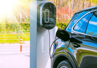 Arabalara e-hareketlilik için yakıt dolduruyorum. Hibrit motor benzini ve elektrik yüklü elektrikli bir araba. Elektrik yenilenebilir enerji kavramı olarak güneş ışığı
