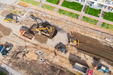 Şehir caddesi inşaatı, iletişim kurulumu kanalizasyon kapakları, oluklar, kaldırımlar. Kaldırım döşeme ve hava manzarası hazırlığı