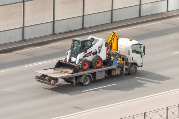 Transportation of a mini tractor by a tow truck