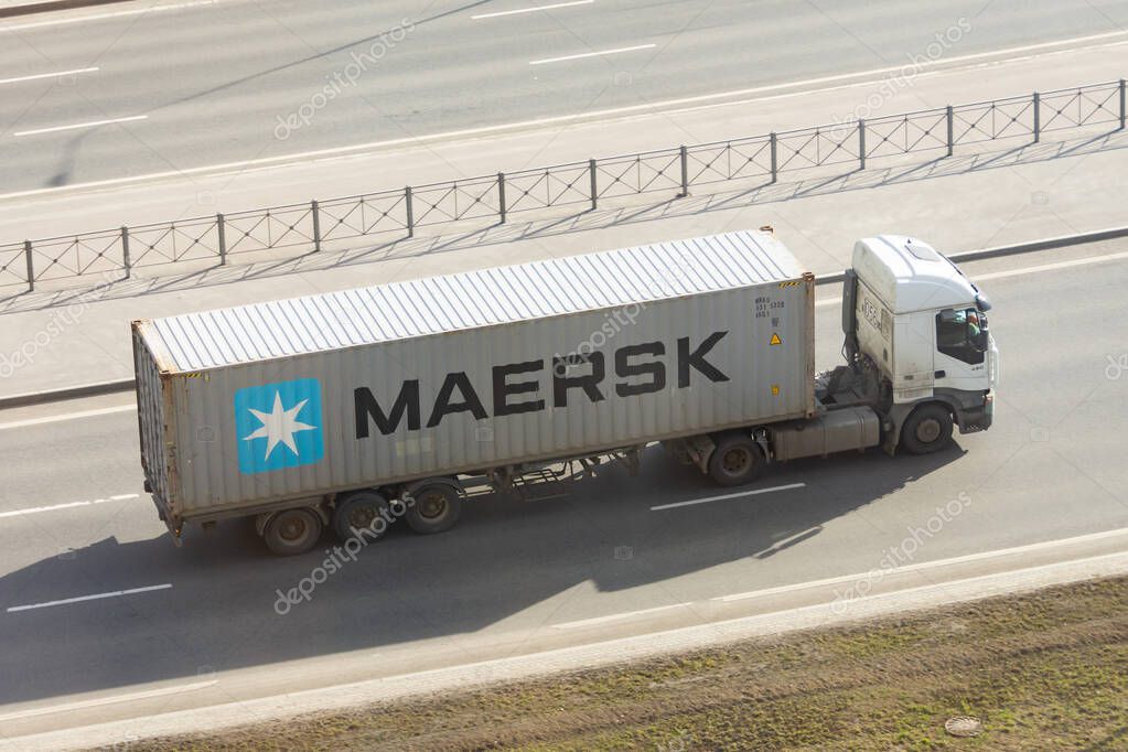 Truck with trailer and green container company Maersk on city highway. Russia, Saint-Petersburg. 15 april 2021