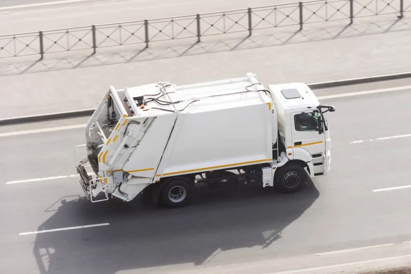 Recycling white truck rides on the road in the city