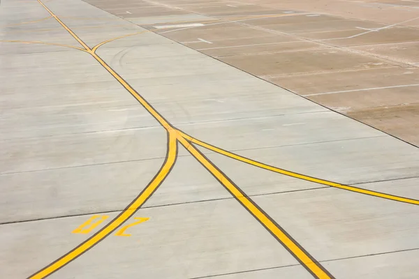 コンクリートアスファルト上のエプロンに空港黄色の誘導路線のマーキング 飛行機のパイロットのためのサイン — ストック写真
