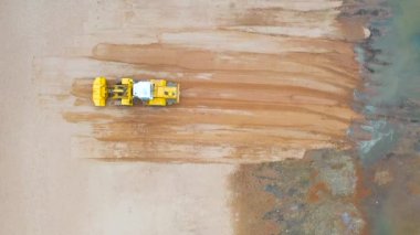 Çalışan toprak taşıyıcısının hava görüntüsü yüzeyi düzleştirir