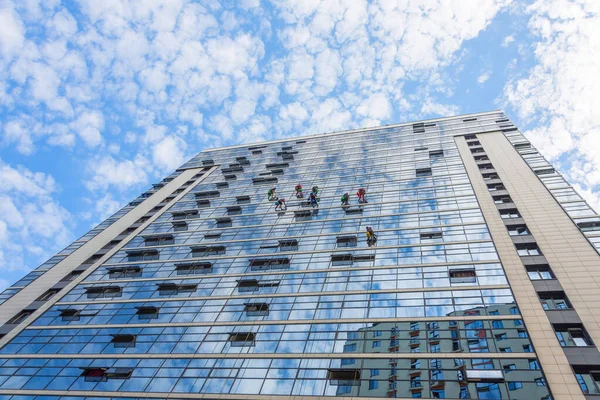 複数階建ての建物のファサードのガラスを洗う建物の外からの登山者のきれいな窓 — ストック写真