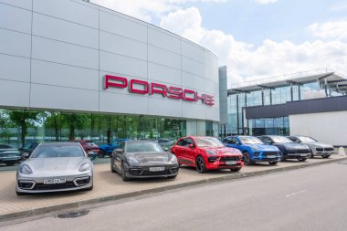 Porsche vagonu, Porsche galerisinde yetkili bir satıcının yanında farklı sınıf makine modelleri. Rusya, Saint-Petersburg, 27 Mayıs 2021