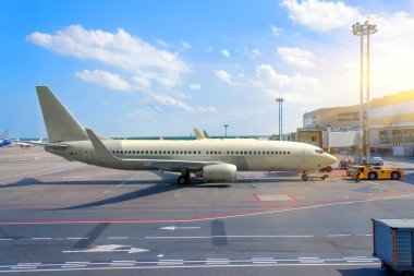 Havaalanı binasının terminalindeki orta büyüklükteki yolcu uçağı uçuştan önce hizmet veriyor.