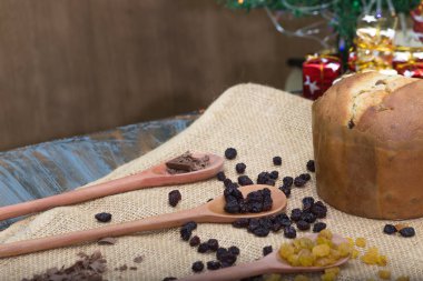 Ahşap kaşıklarla dolu rustik Noel masası. Üzüm ve Noel Panettone.