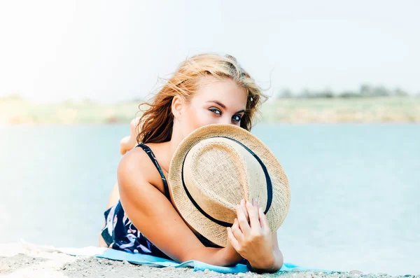 帽子捂着嘴的海滩上的年轻女子 — 图库照片