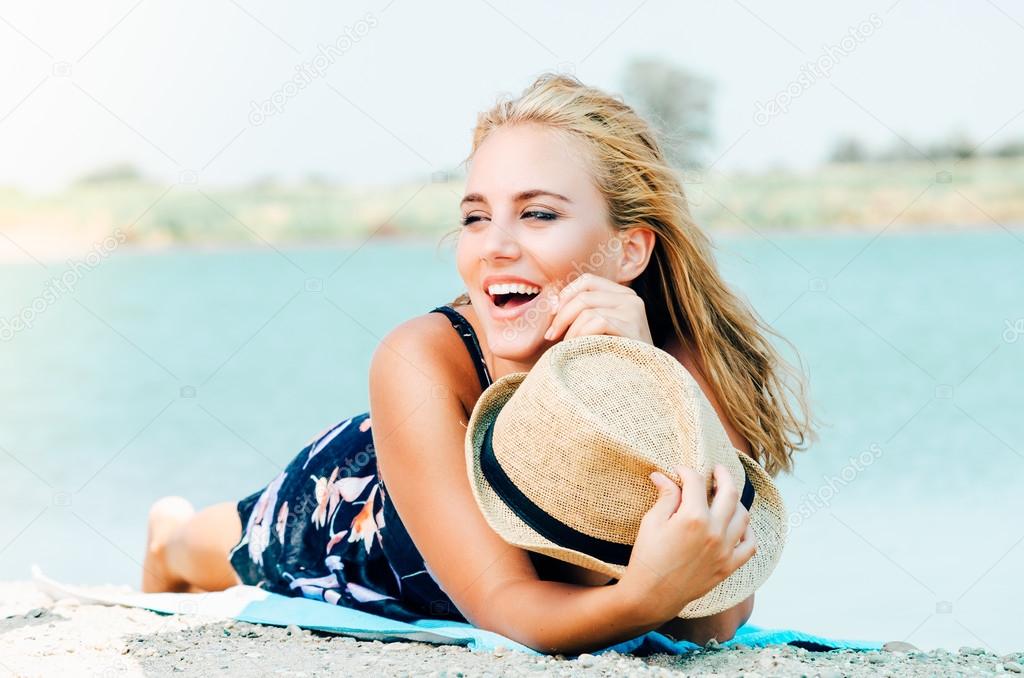 Young smiling woman with hat on the beach