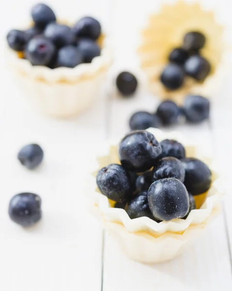 Frutta Chokeberry in torta tazza gialla su tavole di legno leggero . — Foto Stock