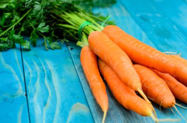 Renkli turkuaz mavi boyalı woode üzerinde taze havuç demet