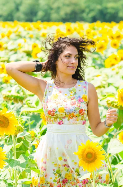 Menina bonita em um campo de girassóis — Fotografia de Stock