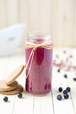Cranberry and black currant smoothie in glass jars with cookies 